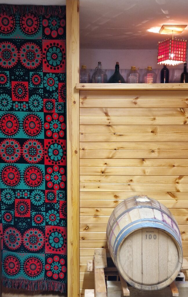 Uso della coperta abruzzese come tenda-separè per impreziosire anche la cantina.